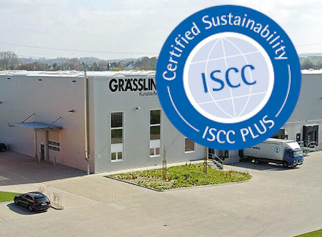 Grässlin-Fabrik mit ISCC-PLUS-Zertifikat für Nachhaltigkeit. Gebäude mit Logo und LKW im Hof.